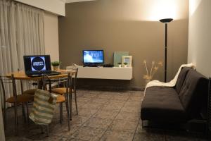 a living room with a couch and a table with a laptop at Argenta Apart Hotel in Trelew