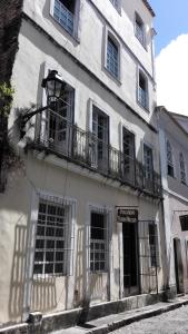 um edifício branco com janelas e uma varanda em Pousada Terra Nossa em Salvador