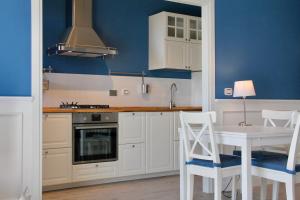 een keuken met witte kasten en een tafel en stoelen bij Le Grand Bleu in Bordighera