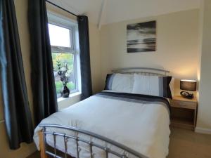 a bedroom with a bed and a window at Birdholme House in Chesterfield