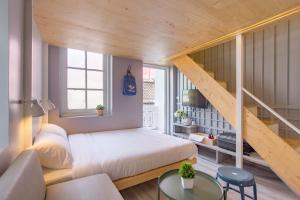 a small bedroom with a bed and a staircase at Norn Yaowarat Hotel in Bangkok