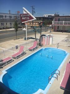 a large swimming pool with chairs and a hotel at Skylark Resort Motel in Wildwood