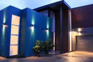 une maison bleue avec des lumières sur son côté dans l'établissement Refreshstay, à Palmerston North
