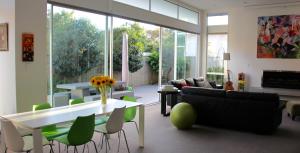 a living room with a couch and a table and chairs at Refreshstay in Palmerston North