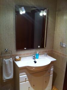 a bathroom with a sink and a large mirror at Hostal El Puerto in Caleta De Velez