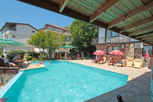 a swimming pool in a resort with people in it at Villas Sozopol in Sozopol