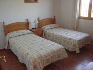 a bedroom with two beds and a window at Apartamentos Las Colinas in Vélez-Málaga