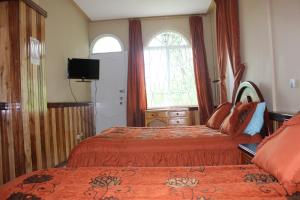 Posteľ alebo postele v izbe v ubytovaní Hostal Mirador de Otavalo