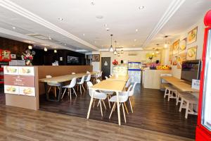 a restaurant with tables and chairs and a kitchen at The Noble Hotel in Singapore