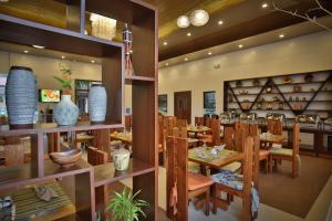 a restaurant with wooden tables and chairs and vases at Coron Soleil Garden Resort in Coron