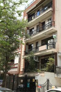 un edificio de apartamentos con balcones en una calle de la ciudad en Tree of Life Bed & Breakfast en Nueva Delhi