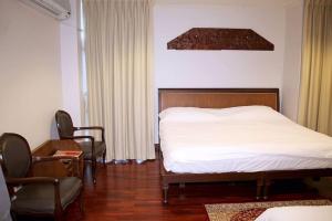 Un pat sau paturi într-o cameră la Samsen Suites/ 2 Br Suites for less
