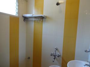 a bathroom with a sink and a toilet and a shower at Sheetal Residency in Bangalore