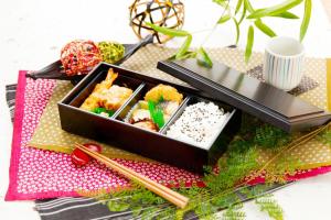 a box of sushi and chopsticks on a table at HOTEL SULATA Sapporo (Adult Only) in Sapporo