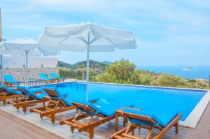 ein Swimmingpool mit Stühlen und einem Sonnenschirm in der Unterkunft Villa Erdo Kalkan 5 Bedroom Villa in Kalkan + 25 Fotos
