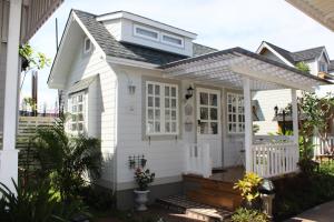 a white house with a porch and a white fence at At Residence Suvarnabhumi Hotel - SHA Extra Plus in Lat Krabang