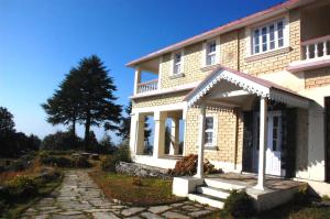 a house with a stone walkway in front of it at Tree of Life Grand Oak Manor Binsar in Binsar