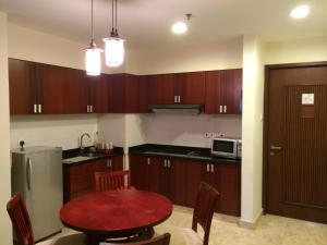 a kitchen with wooden cabinets and a red table at Ian's Vacation Rental in Skudai