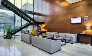 a lobby with couches and a tv on a wall at Sercotel JC1 Murcia in Murcia