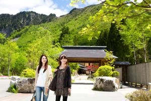 two girls standing in front of a building at Miyama Ouan in Takayama