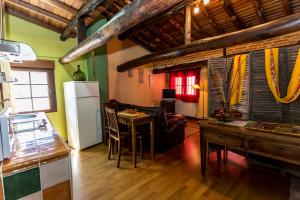 cocina y sala de estar con mesa y nevera en El castanar, en San Esteban de la Sierra