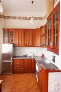 a kitchen with wooden cabinets and a stainless steel refrigerator at Apartament Erfolg 8 in Daugavpils