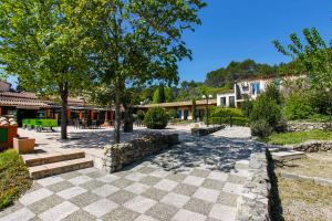 a courtyard with trees and a stone wall at Le Domaine du Thronnet in Figanières