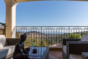 uma estátua sentada numa mesa em frente a uma varanda em Villa Le Port d'attache em Vallauris