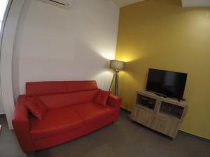 ナポリにあるアッリンカント ディ マリーのリビングルーム(赤いソファ、薄型テレビ付)