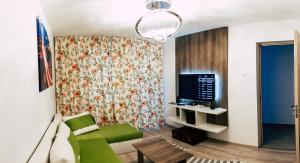 ein Wohnzimmer mit einem Sofa und einem TV in der Unterkunft Nicola's Home in Bukarest