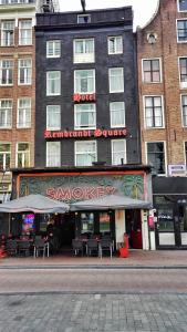 a building with a restaurant with chairs in front of it at Rembrandt Square Hotel in Amsterdam