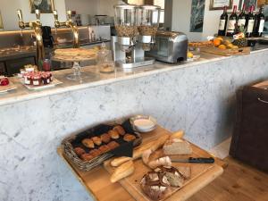 a table with a tray of bread and pastries at Les chambres du Waterzooi in Dunkerque