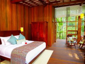 a bedroom with a large bed in a room at Niraamaya Retreats Cardamom Club in Thekkady +37 photos