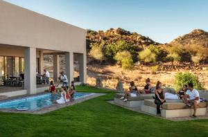 a group of people sitting on couches by a pool at Springbok Inn in Springbok