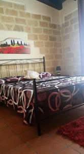 een bed in een kamer met een bakstenen muur bij Casale Del Golfo in Castellammare del Golfo