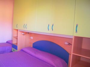 バデージにあるSea House Sardinia - Casa Smeraldoのベッドルーム1室(ベッド1台付)、キャビネットが備わります。
