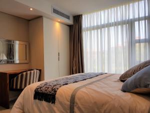 a bedroom with a bed and a large window at Zimbali Suites 109 in Ballito