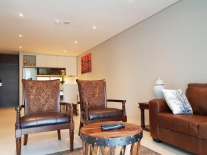 a living room with a couch and chairs and a table at Zimbali Suites 109 in Ballito