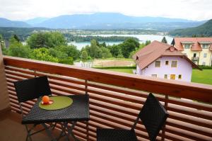 a patio area with chairs, a table, and a balcony at Alpe-Adria Apartments in Oberaichwald