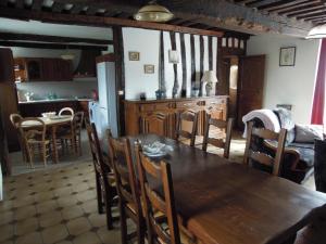 a kitchen and dining room with a wooden table and chairs at manoir de saint supplix in Octeville-sur-Mer