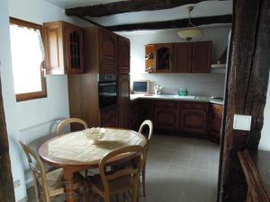 uma cozinha com uma mesa e uma mesa e cadeiras em manoir de saint supplix em Octeville-sur-Mer