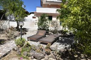 a couple of benches sitting in a garden at Villa Arancio Giorgio in Cala Liberotto