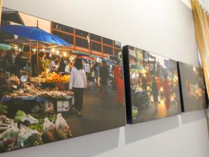 un grupo de fotos colgando de una pared en un mercado en โรงแรมนางรอง en Nang Rong