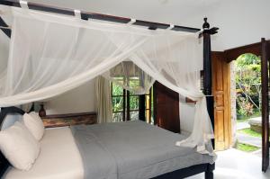 Postel nebo postele na pokoji v ubytování Yuliati House Ubud
