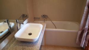 a bathroom with a sink and a bath tub at Kalias Hotel in Vasiliki