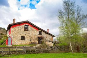 una antigua casa de piedra con una valla de madera en Casa Rural La Torraya en Sirviella