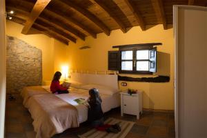 Sirviella的住宿－Casa Rural La Torraya，两个女孩坐在房间里的床边