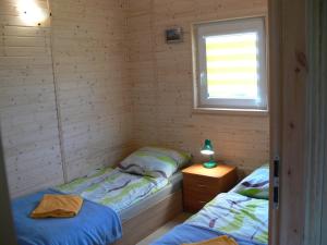 two twin beds in a room with a window at Kalski Dworek in Węgorzewo