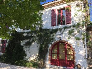 TourvesにあるBastide Saint Supinの赤窓と木のある白い建物