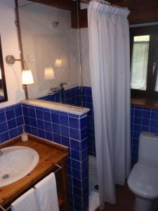 a blue tiled bathroom with a sink and a toilet at Casa Rural Ogoño Mendi in Elanchove